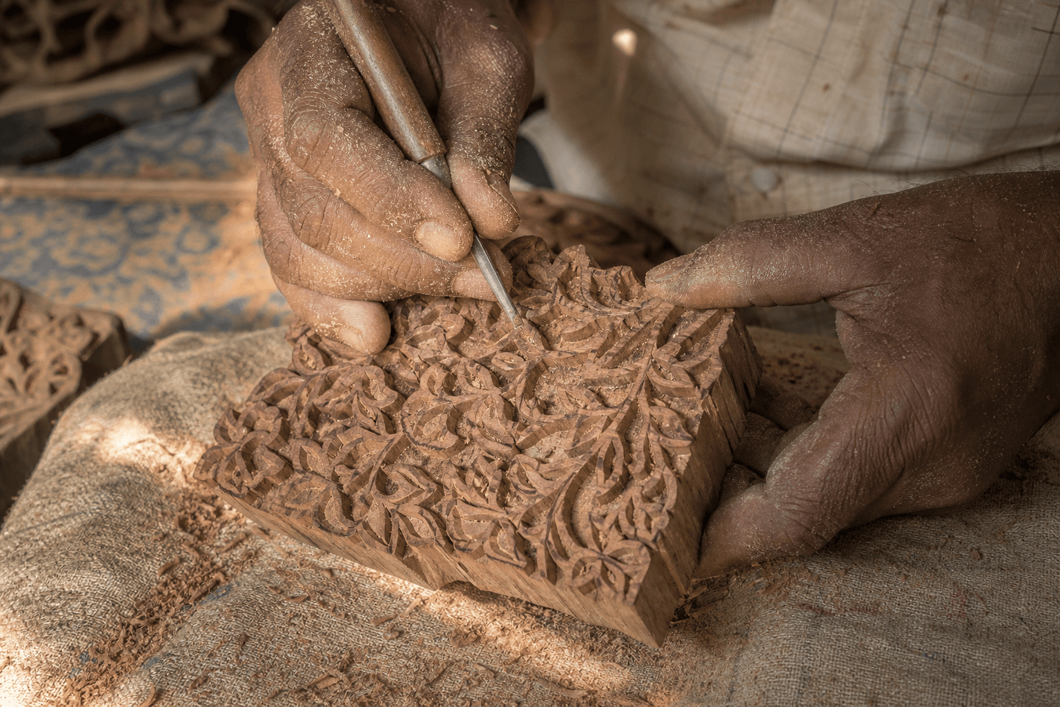 Hands tying Bandhani knots on fine cotton and silk